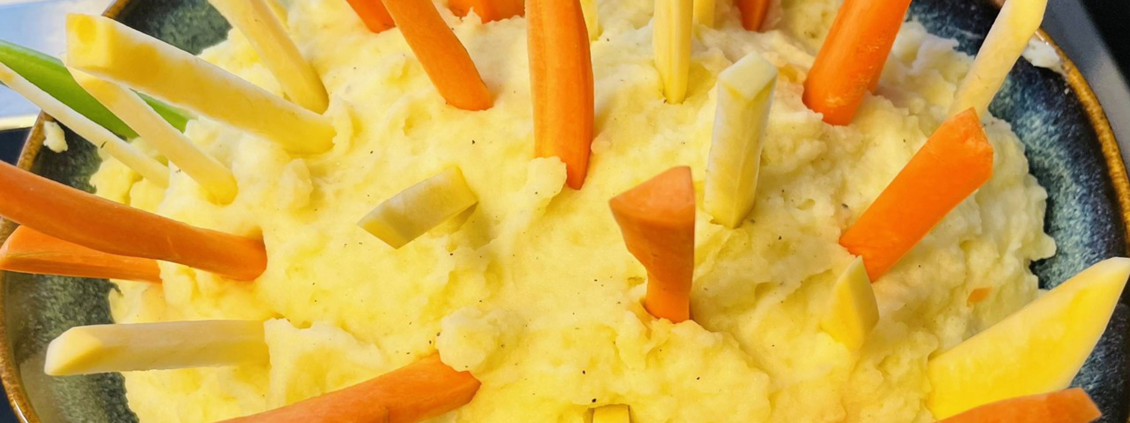 Gulerotstenger og kålrotstenger som står i ei gryte med plukkfisk