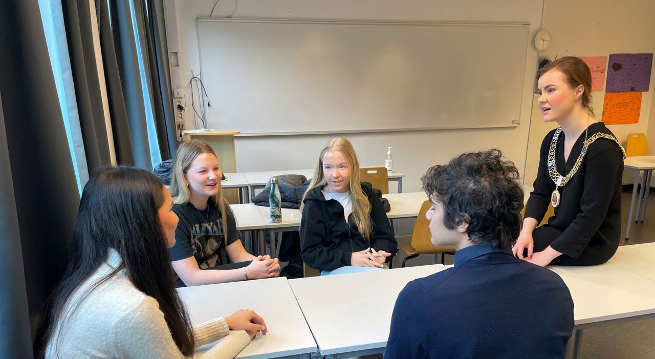 Ordfører Linn Kristn Engø snakkar med fire elevar i eit klasserom