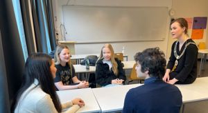 Ordfører Linn Kristn Engø snakkar med fire elevar i eit klasserom
