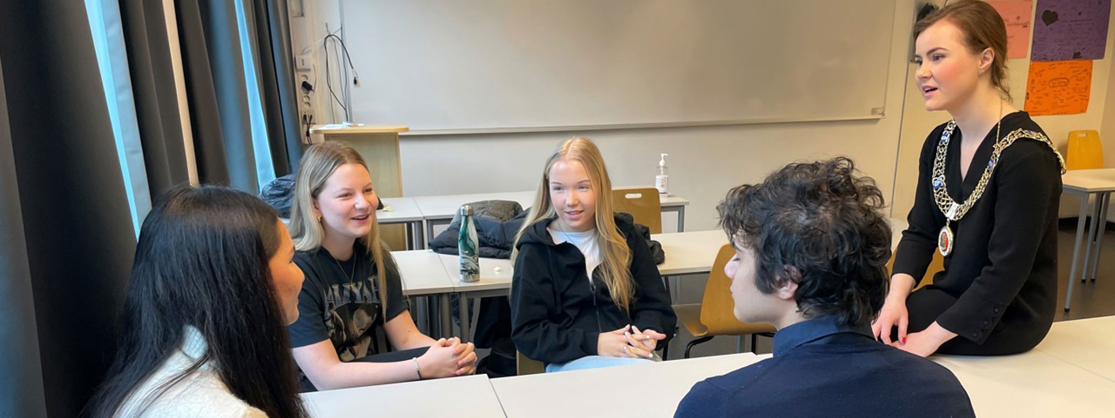 Ordfører Linn Kristn Engø snakkar med fire elevar i eit klasserom