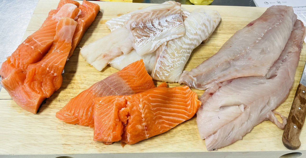 Laks-, torsk-, aure-, og seifillet ligg på ei skjerefjøl