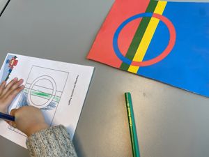 Ein elev fargelegg eit samisk flagg