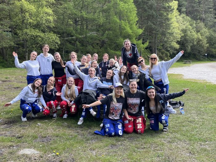 Gruppe bliete av heile klasse 3 Helse og oppvekstfag som sit på ein grønn plen uti skogen
