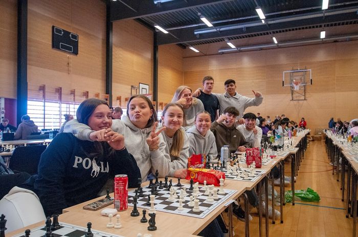 9 elevar står bak sjakkborda i gymsalen