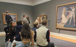 Elevar sit på ein sofa framfor eit Edvard Munch bilete .