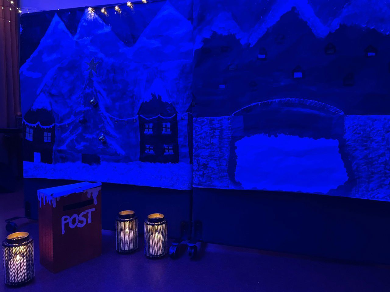 Kullisar med malte hus og lys lykter på golvet