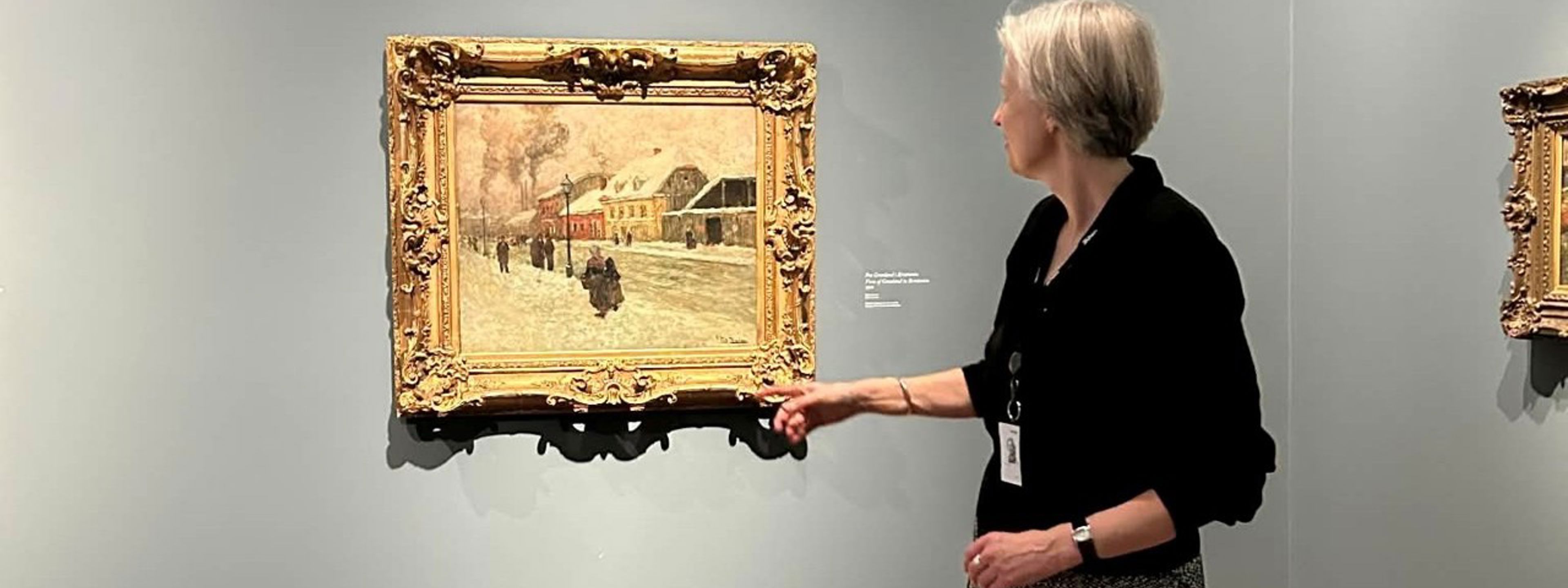 Ein kvinneleg omvisar fortel om eit måleri som heng på veggen