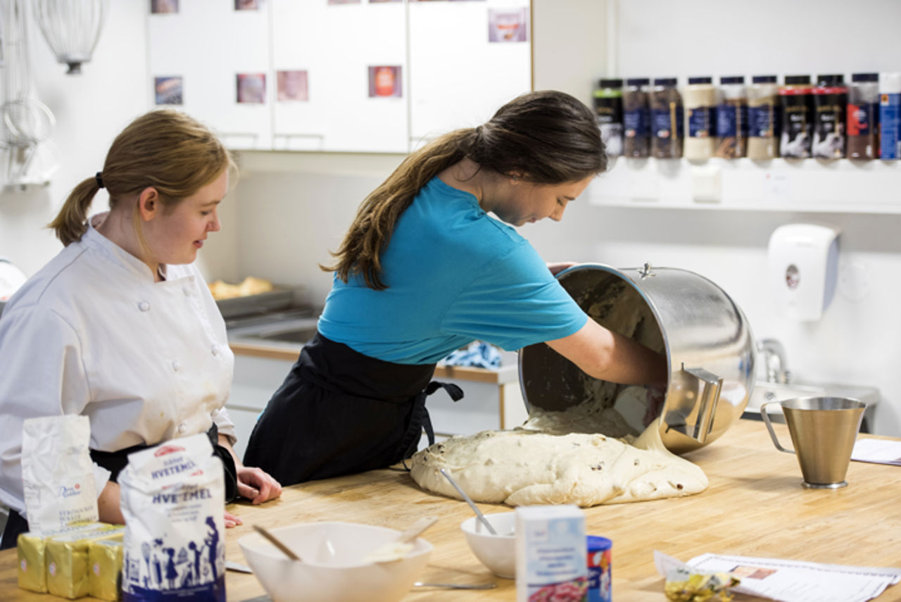 To elevar som tar deig ut av ein bakebolle
