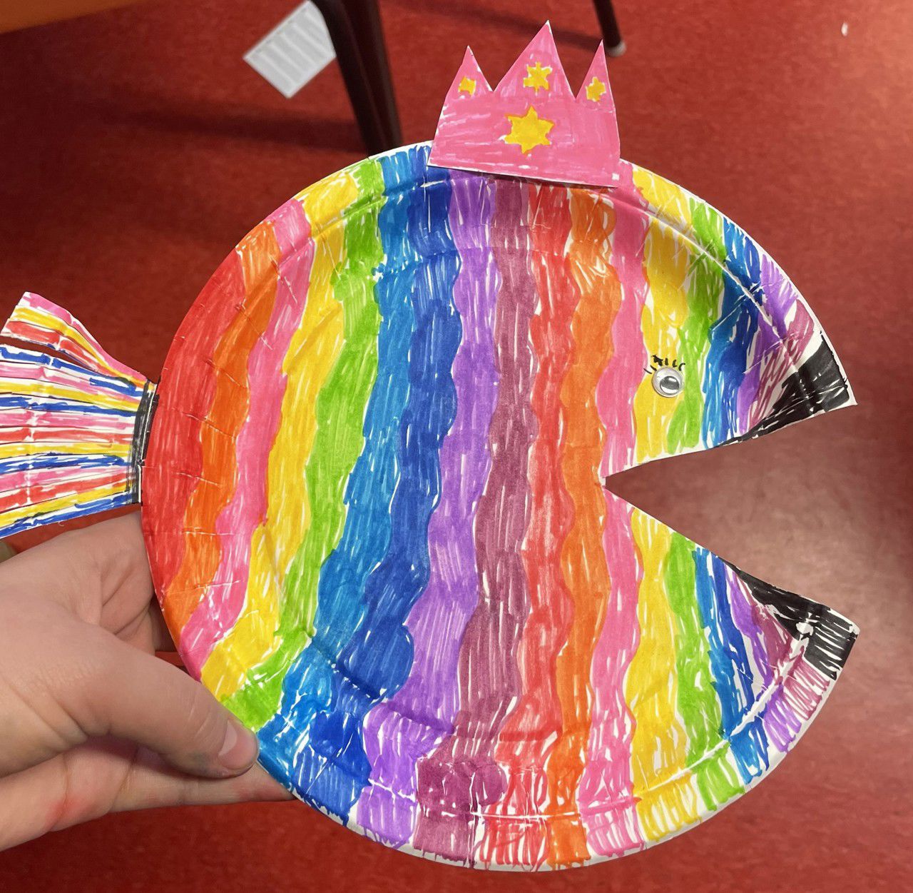 Ein ferdig fagelagt papptallerken som er klipt til som ein rund fisk med open munn