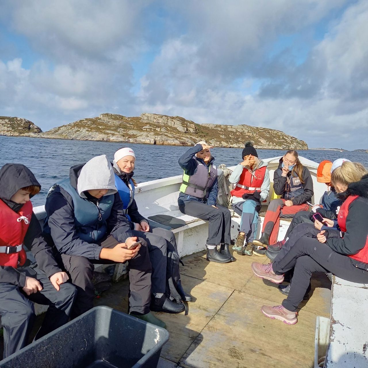 Mange elevar sit i ein fiskebåt