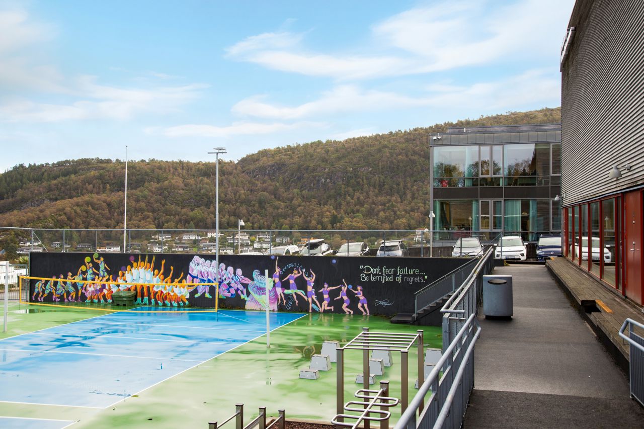 Utebilete av volleyball bana med ein grafittivegg i bakgrunnen