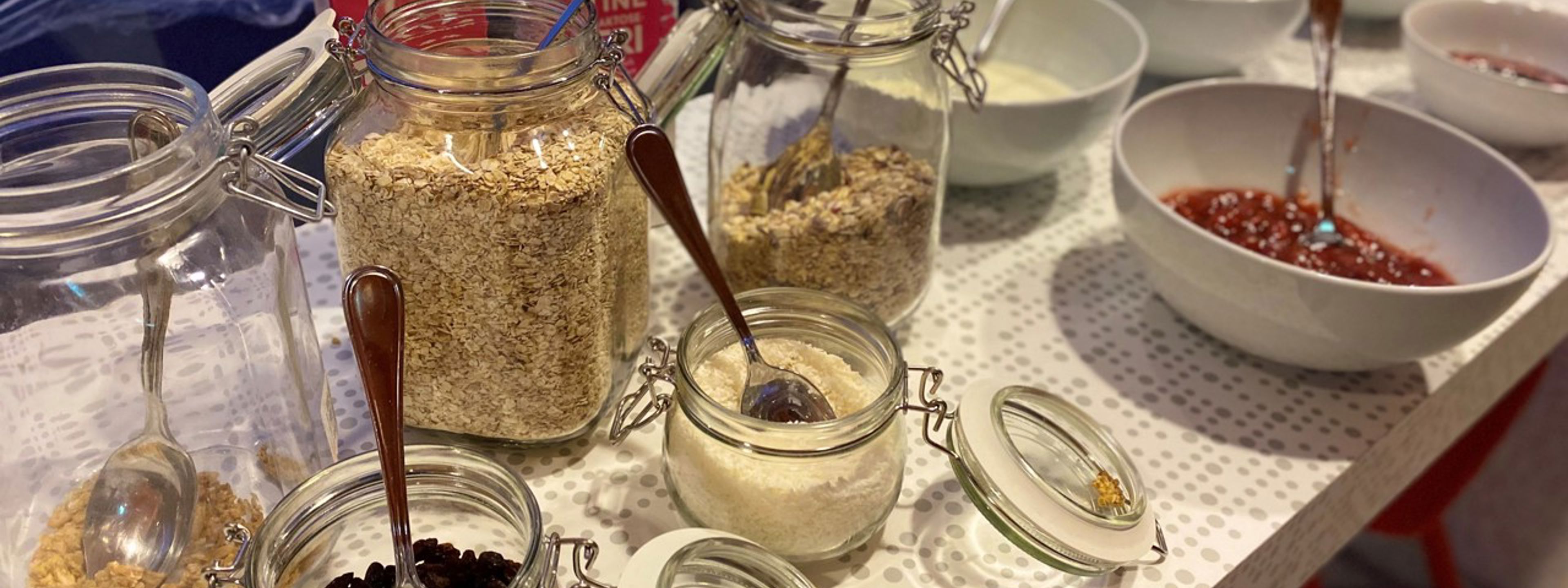 Ulike typar gryn, yoghurt og syltetøy står på eit bord