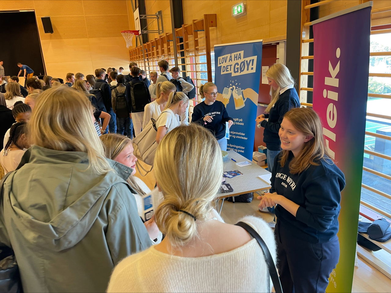3 jenter frå unge Høyre står framfor sine plakater og snakkar med elevar