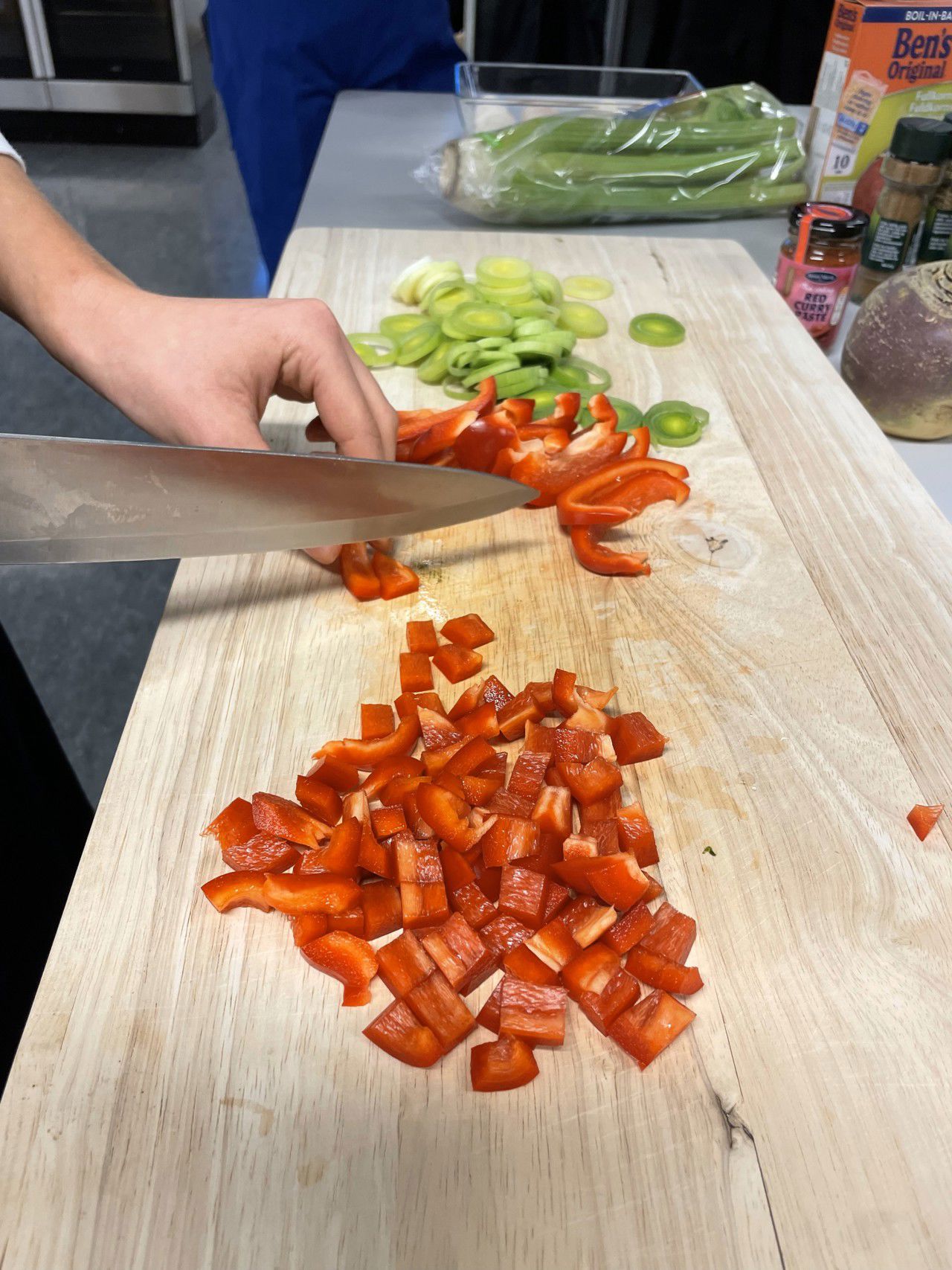 Ein elev som kuttar opp paprika med kniv.