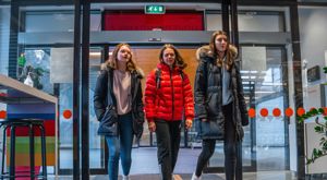 Tre jenter går inn hoved døra på skulen