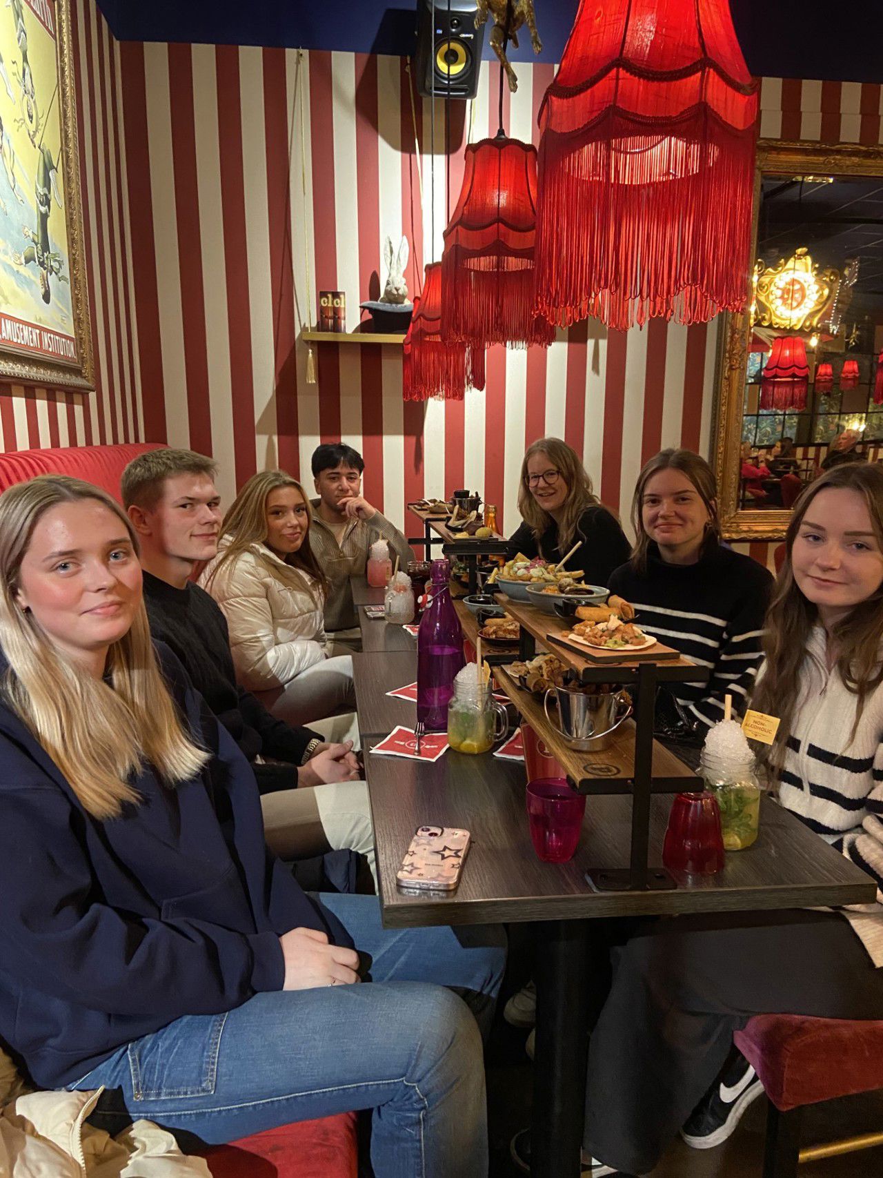 6 elevar og ein lærar sit å et på ein restaurant